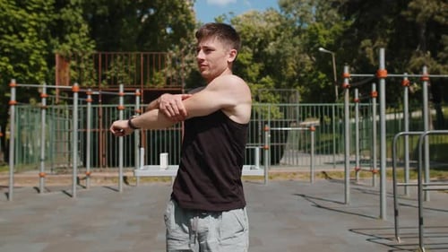 Man Stretching Before Workout in Outdoor Fitness Area