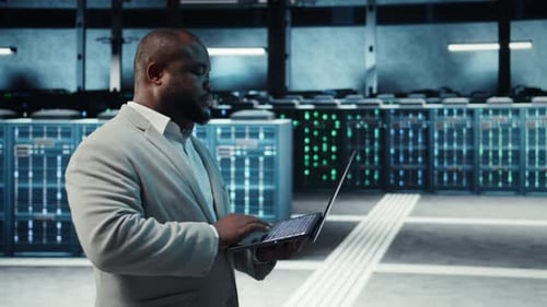 Man Using Laptop in Data Center