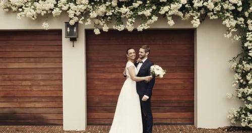 Happy Wedding Couple Embracing with Floral Backdrop