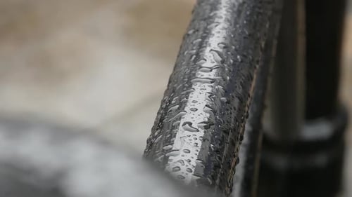 Une photo prise à main levée mettant l'accent sur l'eau sur ce mât noir sous la pluie