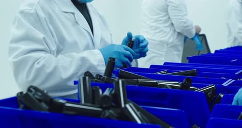 Lab technician on the assembly line packs cannabis pre-rolls into a tube that will be sold in dispen
