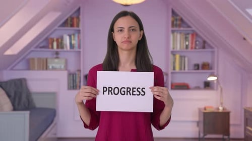 Sad Indian woman holding PROGRESS banner