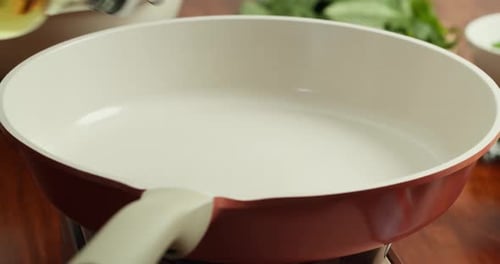 Manual Pouring of Olive Oil Into a Frying Pan for Cooking Preparing to Fry a Delicious Dish in the