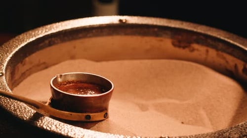 Traditionellen türkischen Kaffee auf dem Sand zubereiten Barista Authentischer türkischer Kaffee auf heißem Sand in einem