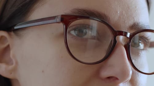 Sehprobleme Nahaufnahme, Porträt einer jungen Frau, die eine Brille aufsetzt und Informationen über liest