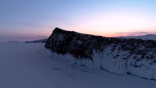 Aerial Over the Rocky Island in Lake Baikal Winter Landscape of Frozen Baikal at Dusk Sunrise
