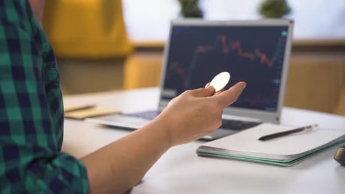 Man Examining Bitcoin with Stock Chart on Laptop