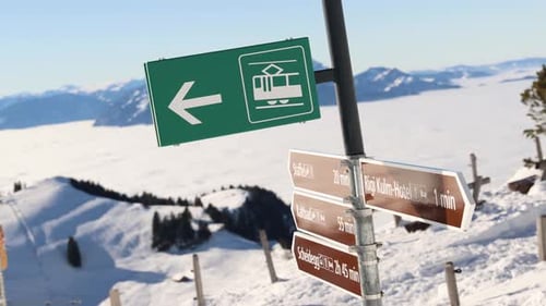 Sign pointing to mountain train station in the alps, establisher