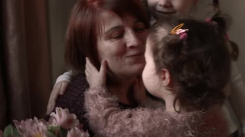 Back View of Girl is Hiding White Flowers Behind Her Back for Grandmother