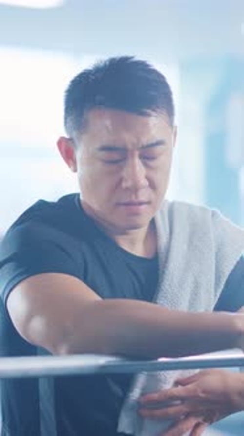 A Focused Individual in the Gym is Taking a Welldeserved Break After an Intense Session