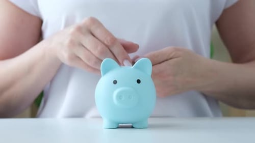 Person Putting Coins Into Piggy Bank for Saving Money Woman Investing in Future