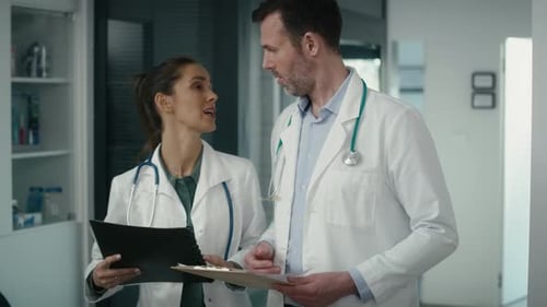 Doctors Discussing Patient File in Hospital Setting