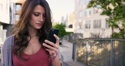4k video footage of a woman using her cellphone while walking outside