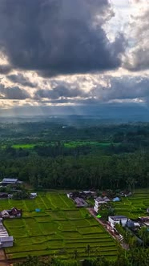 De sombres nuages flottent au-dessus d'un paysage rural.