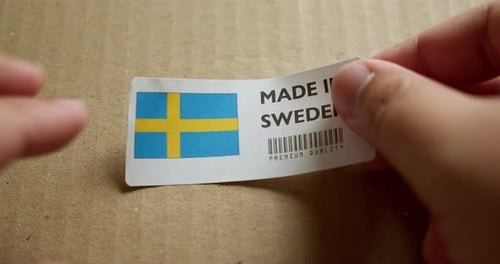 Applying Made in Sweden Label to Cardboard Box