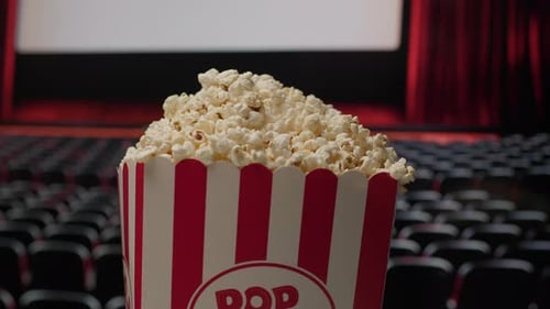 Rotating Popcorn Basket with Cinema Screen in Background