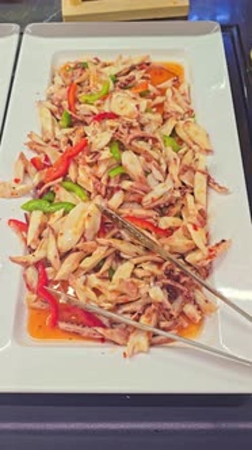 Close-Up Moving Toward Pasta Salad with Bell Peppers and Squid Tentacles at Buffet Restaurant