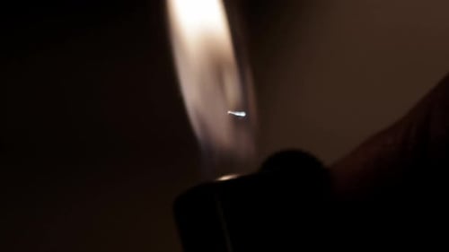 Lighter Ignites in Darkness: Close-up of Flickering Flame