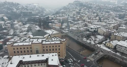 A cinematic drone aerial view of Sarajevo’s Old Town, gently blanketed in fresh snow.