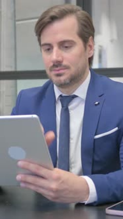 Focused Adult Using a Tablet in Office Setting