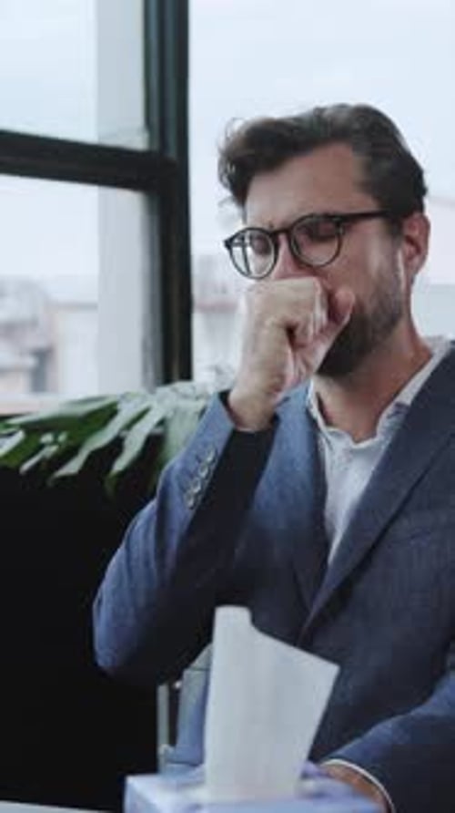 Adult with Cold Coughing into Hand and Using Tissues