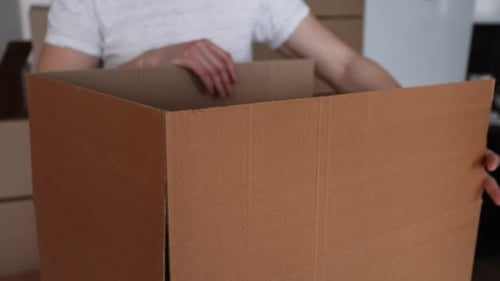 Closeup Cropped Shot of Unrecognizable Man Packing Big Cardboard Box for Personal Stuff Storing at
