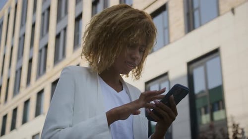 Woman Using Smartphone Outside Modern Building