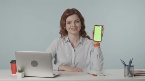 Young Adult Woman Holds Green Screen Phone