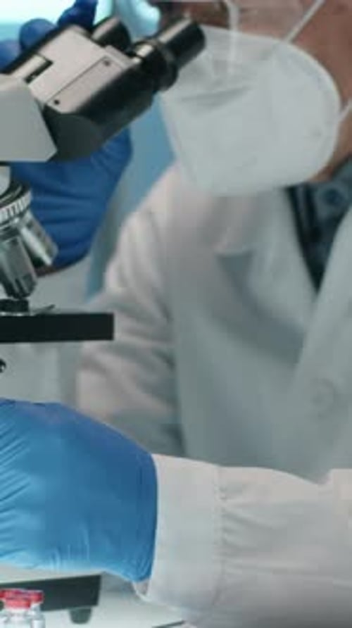 Senior Scientist Uses Microscope in Laboratory Setting