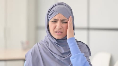 Young Woman Rubbing Temple Due to Headache