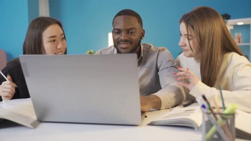 Three Young Adults Working Together on a Laptop