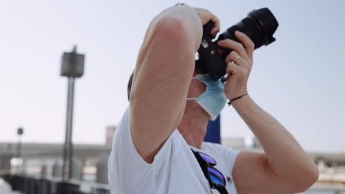 Man with Camera Taking Photos in Urban Setting