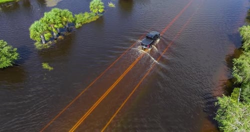 Flooded Street After Hurricane Rainfall with Driving Cars in Florida Residential Area Consequences