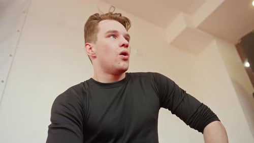Male Fighter Resting After Sparring in Gym Wearing Black Sportswear