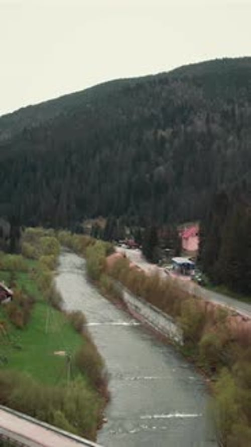 Drohne fliegt über Wald und Fluss in den Karpaten. Vertikales Video