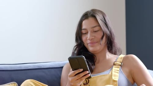 Woman Using Credit Card, Smart Phone on Couch