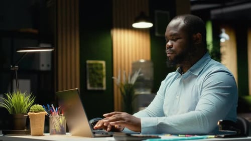 Man Working On Laptop Computer In Modern Office