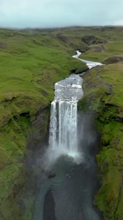 Skogafoss Waterfall Cascades Through Lush Icelandic Landscape