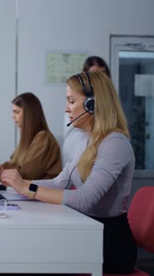 Professional Female Support Agents Working at Computers in Modern Customer Service Call Center