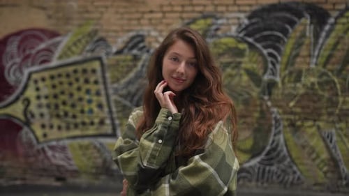 Stylish Woman Posing in Front of Graffiti Wall
