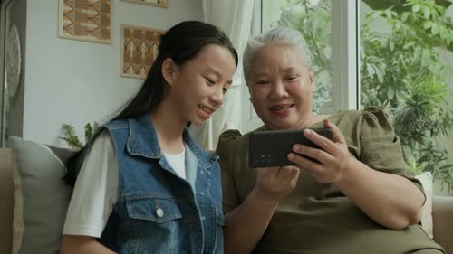 Grandmother and Granddaughter Looking at a Smartphone