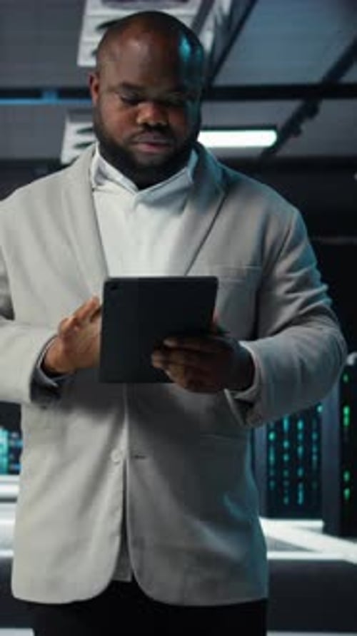 Vertical Video System Administrator Walking in Data Center Analyzing Infrastructure Performance