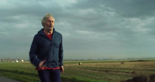Senior Man Jogging on Rural Road for Fitness