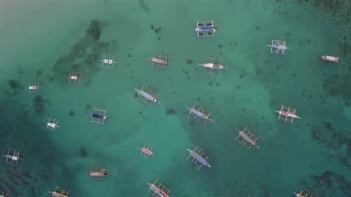 Boracay, de nombreux bateaux ancrés dans des eaux cristallines turquoises, des coraux visibles. Panorama aérien à droite,