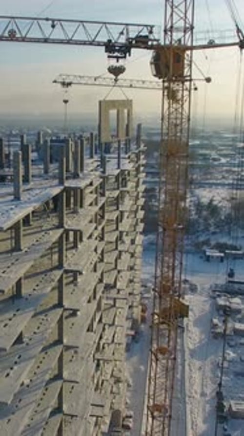 Construction Progress of Highrise Building in Winter Under Clear Sky with Cranes in Action