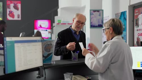 Customer Receiving Prescription at Pharmacy Counter