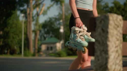 Young Lady Dropping Roller Skates on Park Bench on Sunny Day