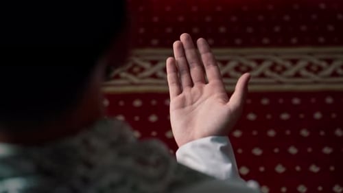 Nahaufnahme der Hände eines muslimischen Mannes, der während des Ramadan im islamischen Tempel auf seinen Knien betet