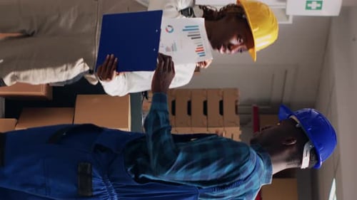 Employees Inspecting Inventory in Warehouse with Boxes