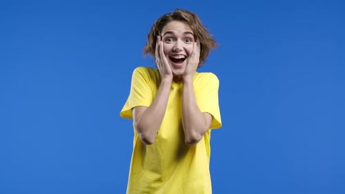Woman Expressing Extreme Excitement on a Blue Background